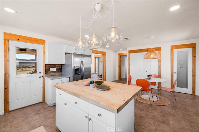 55850 Shannon Rd, Landers, CA 92285 - kitchen with recessed lighting, white cabinetry, stainless steel fridge with ice dispenser, a kitchen island, and wooden counters