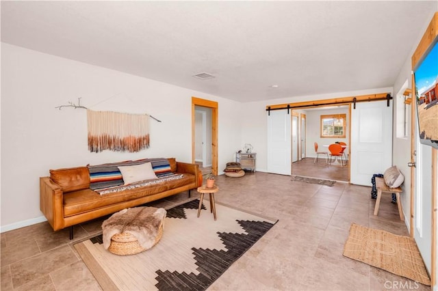 55850 Shannon Rd, Landers, CA 92285 - living room featuring a barn door, visible vents, and baseboards