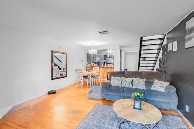 living area with visible vents, baseboards, and wood finished floors
