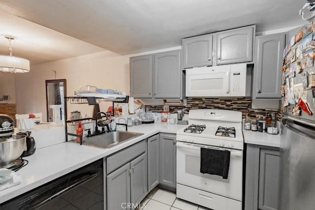 kitchen with white appliances, a sink, gray cabinets, and light countertops