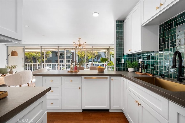 1400 N Sweetzer Ave Unit 102, West Hollywood, CA 90069 - kitchen featuring dark countertops, a sink, a peninsula, white cabinets, and recessed lighting