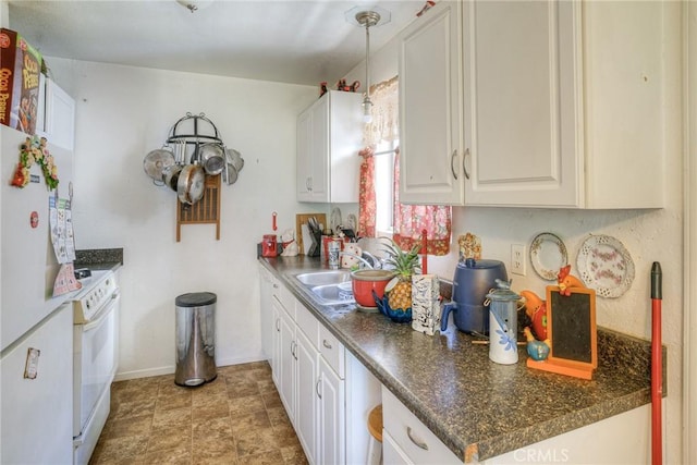 kitchen with white cabinets, white appliances, dark countertops, and a sink