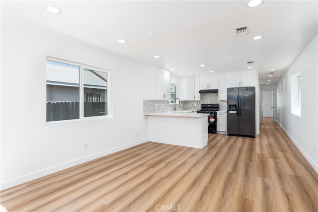 kitchen featuring black appliances, recessed lighting, white cabinetry, healthy amount of natural light, and light countertops
