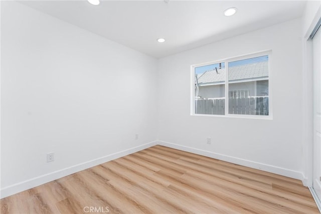 spare room featuring wood finished floors, baseboards, and recessed lighting