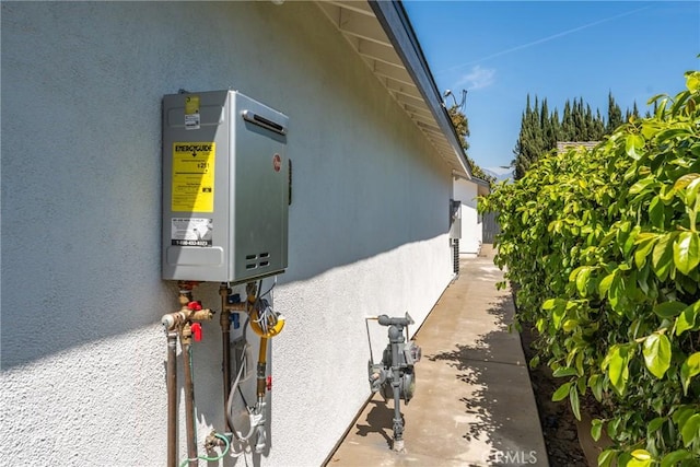 view of side of home with stucco siding and water heater