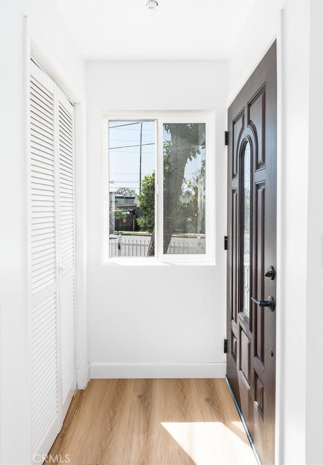 entryway with light wood-style flooring and baseboards