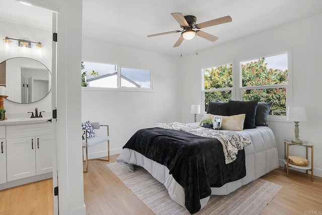 bedroom with baseboards, multiple windows, and light wood-style floors