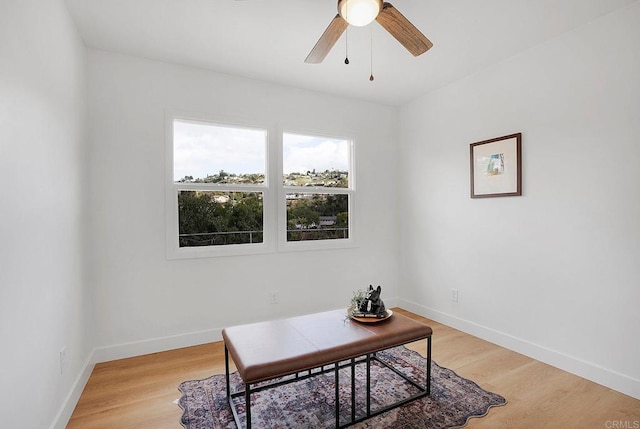 office area with light wood-style flooring, baseboards, and ceiling fan