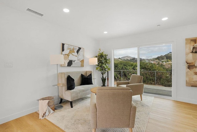 sitting room featuring baseboards, light wood finished floors, visible vents, and recessed lighting