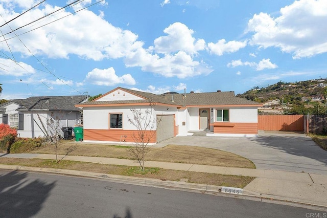 ranch-style house with stucco siding, driveway, a garage, and fence