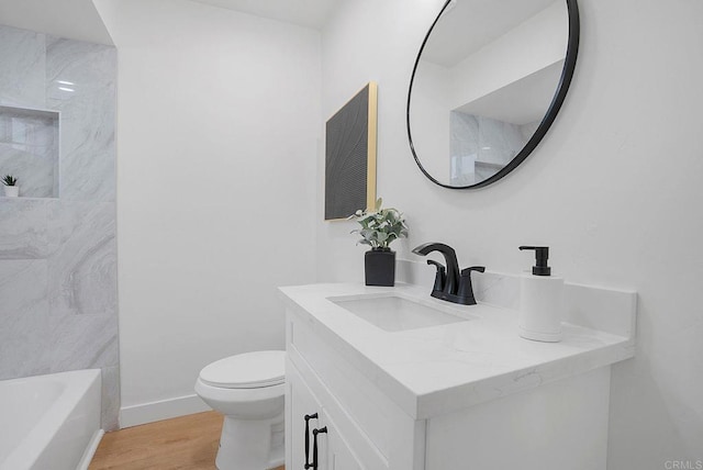 full bathroom featuring a tub to relax in, wood finished floors, toilet, vanity, and walk in shower