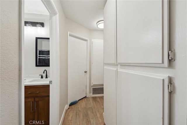 10616 Jamul Rd, Apple Valley, CA 92308 - bathroom with baseboards, wood finished floors, visible vents, and vanity