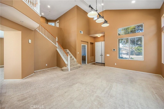 6356 Claridge Dr, Riverside, CA 92506 - unfurnished living room with carpet flooring, high vaulted ceiling, stairs, baseboards, and visible vents