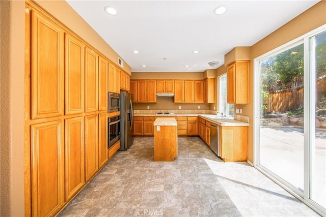 6356 Claridge Dr, Riverside, CA 92506 - kitchen featuring visible vents, appliances with stainless steel finishes, a center island, light countertops, and under cabinet range hood