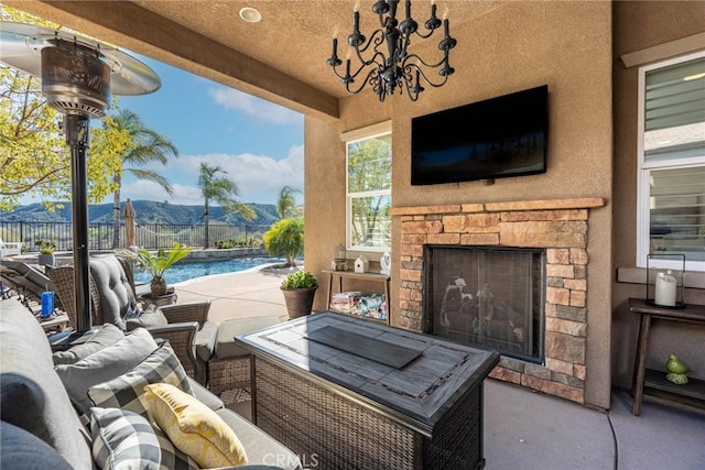view of patio featuring fence, an outdoor living space with a fireplace, and a fenced in pool