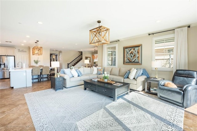 living area with recessed lighting, a chandelier, stairway, and crown molding