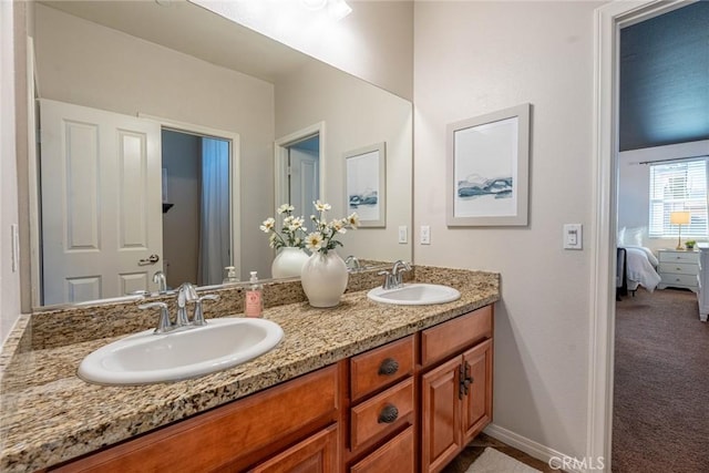 full bath featuring double vanity, connected bathroom, and a sink