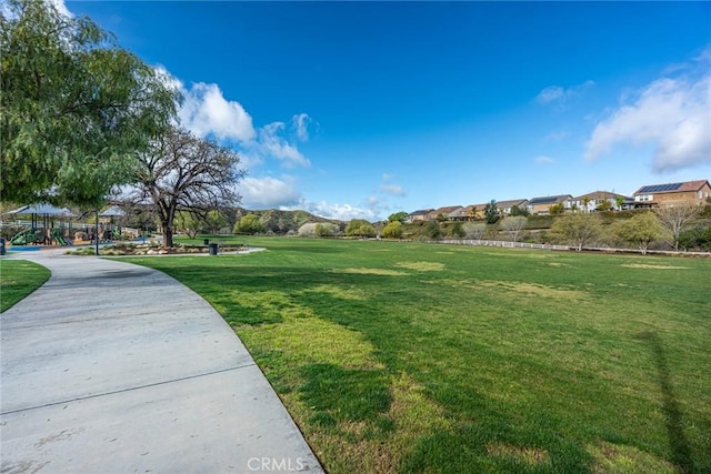 view of home's community with playground community and a lawn