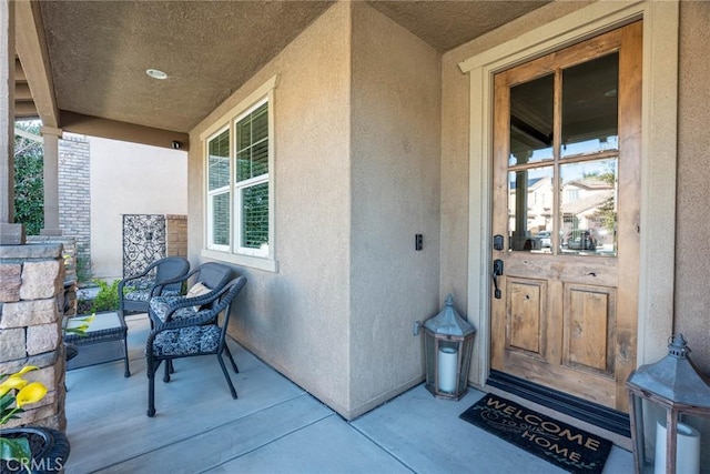 entrance to property with stucco siding and a porch