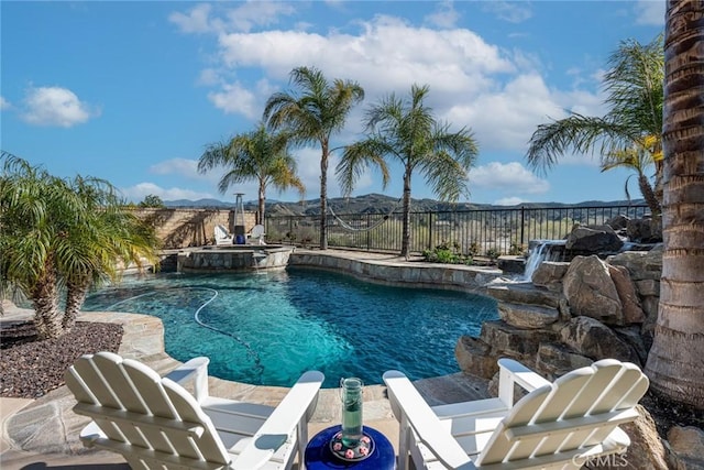 view of swimming pool with a fenced backyard and a pool with connected hot tub