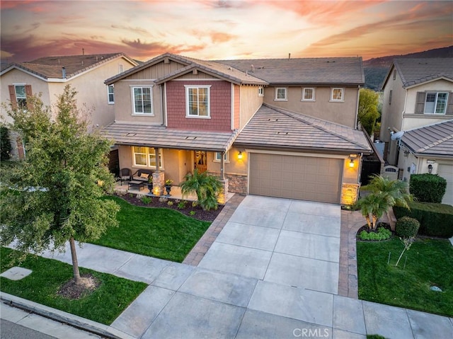 22514 Brightwood Pl, Saugus, CA 91350 - craftsman-style house with concrete driveway, a garage, a porch, a yard, and stone siding