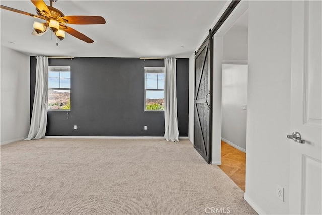 22514 Brightwood Pl, Saugus, CA 91350 - unfurnished bedroom featuring light carpet, a barn door, multiple windows, and a ceiling fan