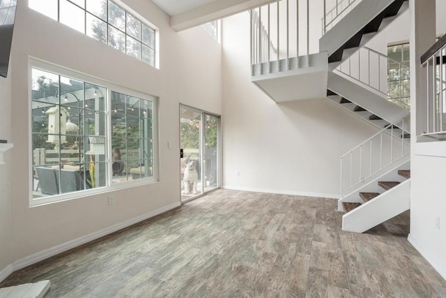 unfurnished living room featuring wood finished floors and baseboards