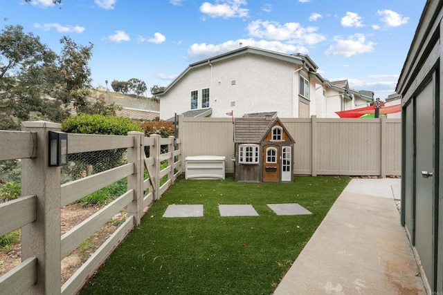 view of yard featuring a fenced backyard, an outdoor structure, and a storage shed