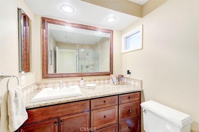 full bath with toilet, vanity, and a stall shower