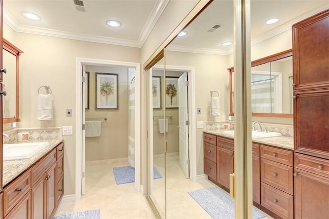 full bath featuring two vanities, a sink, and visible vents