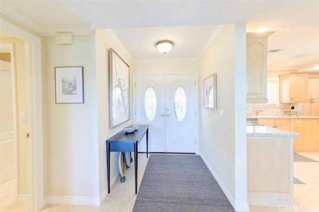 entryway featuring crown molding and baseboards