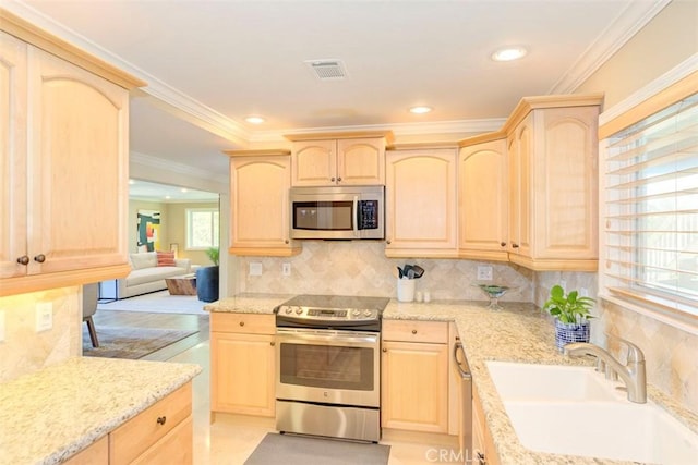 kitchen featuring light brown cabinets, visible vents, a sink, and appliances with stainless steel finishes