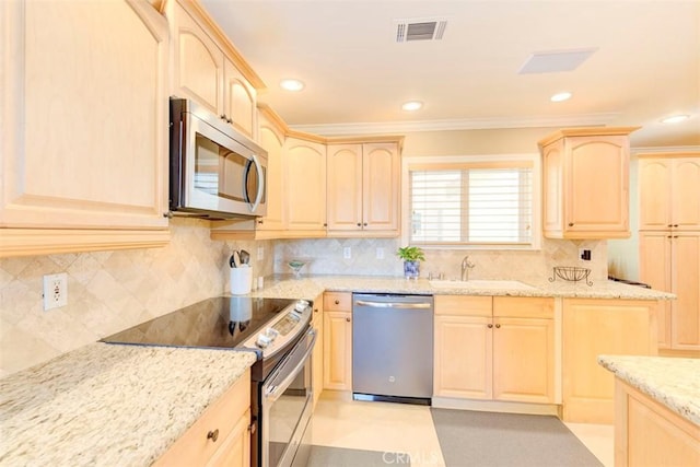 kitchen featuring light stone counters, a sink, light brown cabinetry, appliances with stainless steel finishes, and visible vents