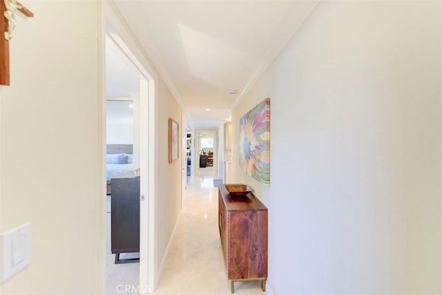 hall featuring crown molding and baseboards