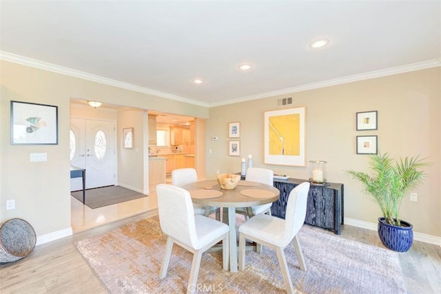 dining area with light wood-style flooring, baseboards, ornamental molding, visible vents, and recessed lighting