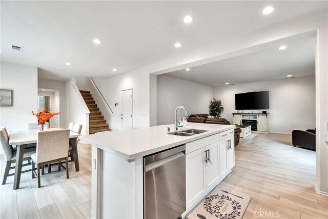 kitchen featuring light wood-style flooring, a sink, open floor plan, visible vents, and dishwasher