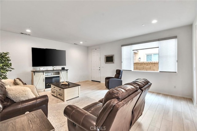 living room with recessed lighting, light wood-type flooring, visible vents, and baseboards