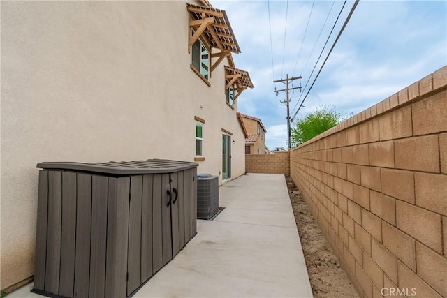 view of side of home with a fenced backyard, a patio area, cooling unit, and stucco siding