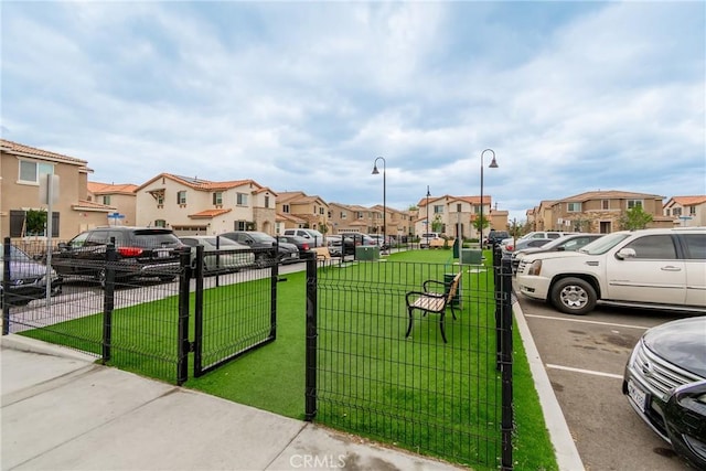 uncovered parking lot featuring fence and a residential view
