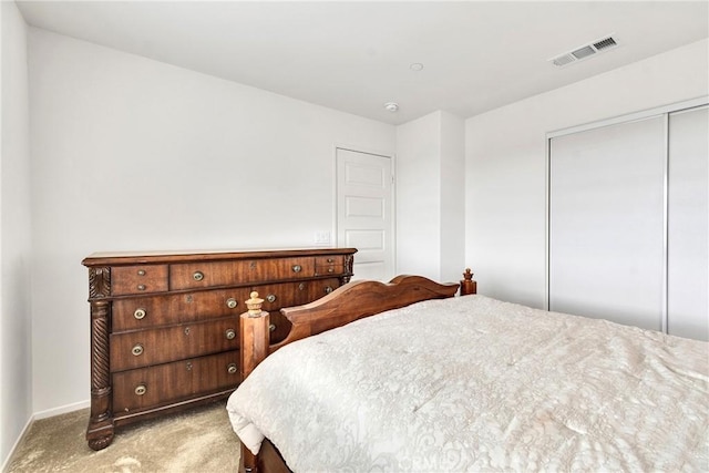 bedroom featuring baseboards, carpet floors, visible vents, and a closet