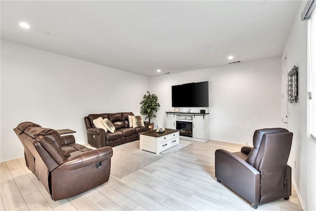 living room with recessed lighting, light wood-type flooring, visible vents, and baseboards