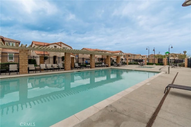 community pool featuring a patio and fence