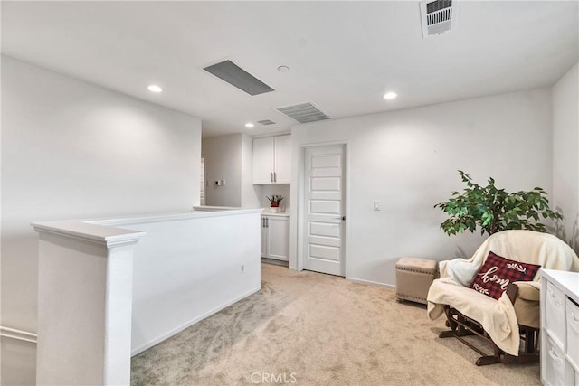 sitting room with baseboards, visible vents, recessed lighting, an upstairs landing, and light colored carpet