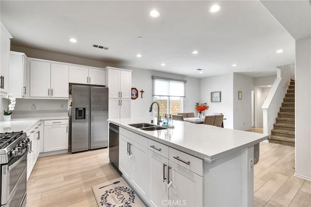 kitchen featuring a sink, light wood-style floors, light countertops, appliances with stainless steel finishes, and visible vents