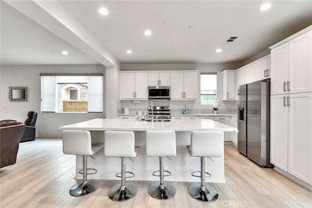 kitchen with white cabinets, a sink, visible vents, light countertops, and appliances with stainless steel finishes