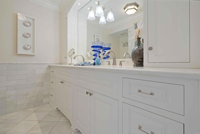 bathroom with wainscoting, vanity, marble finish floor, and crown molding