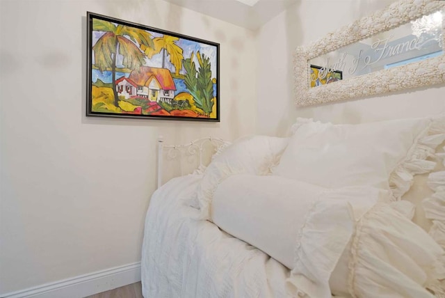bedroom with wood finished floors and baseboards