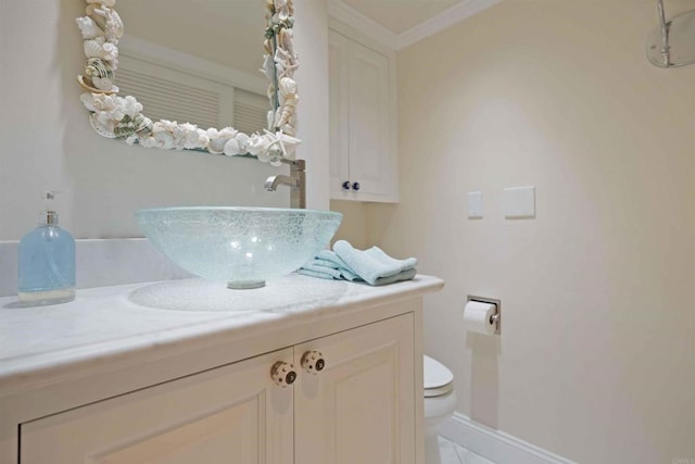 bathroom featuring baseboards, toilet, vanity, and ornamental molding