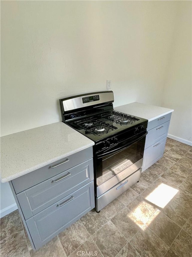 341 N Isabel St, Glendale, CA 91206 - kitchen featuring stainless steel range with gas cooktop, baseboards, gray cabinetry, and light stone counters