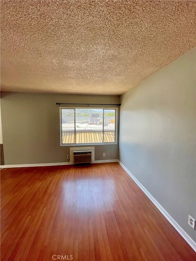 341 N Isabel St, Glendale, CA 91206 - empty room featuring a wall mounted AC, baseboards, wood finished floors, and a textured ceiling